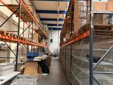 des rayonnages dans un entrepôt, sur lesquels sont empilées des caisses et encore des caisses de denrées alimentaires