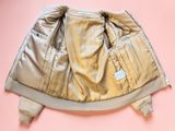 the back of a tan jacket on a pink background