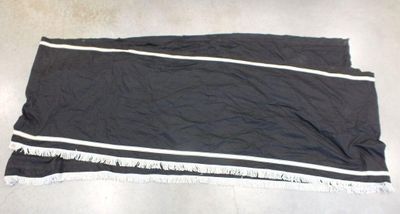 une serviette noire à rayures blanches posée par terre