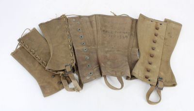 four pairs of leather boots are lined up on a white surface