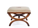 un petit tabouret en bois surmonté d'un coussin beige
