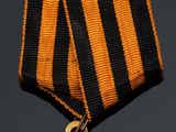 a gold medal with a black and orange ribbon around it