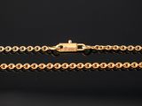 a gold chain with a clasp on a black background