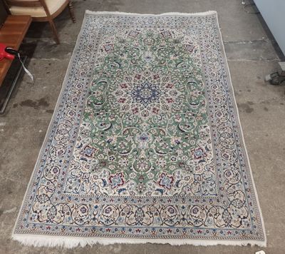 an oriental rug on the ground with a chair and a table in the background