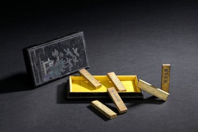 a small box with wooden blocks in it on a black surface