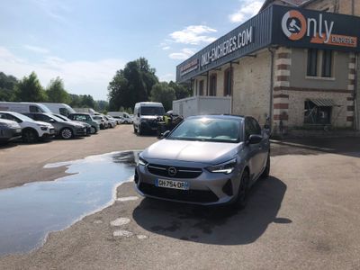 a car parked in front of a building with a lot of parked cars in front of it