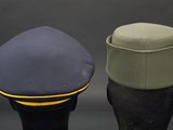 two hats are sitting next to each other on a black surface
