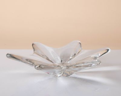 clear glass flower shaped dish on a white surface