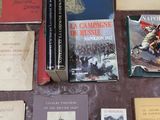 several books are laid out on a table next to a pen