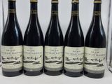six bouteilles de vin sont alignées sur une table