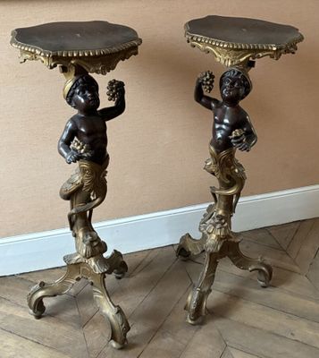 paire de statues antiques en bronze représentant des chérubins, posées sur des socles et disposées sur un plancher en bois