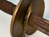 a close up of a sword with a wooden handle