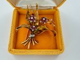 a small yellow box with a brooch of flowers in it