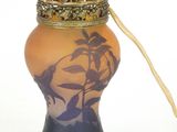 a small vase with a lid and a wooden stick in it