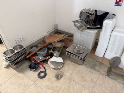 une pile de vaisselle et de casseroles sales par terre