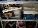 many dishes and pans on the shelves in the kitchen