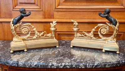 two statues sitting on a marble table with a clock in the background