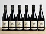 six bouteilles de vin sont alignées sur une table en bois