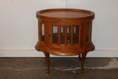 une petite table en bois munie d'une porte vitrée
