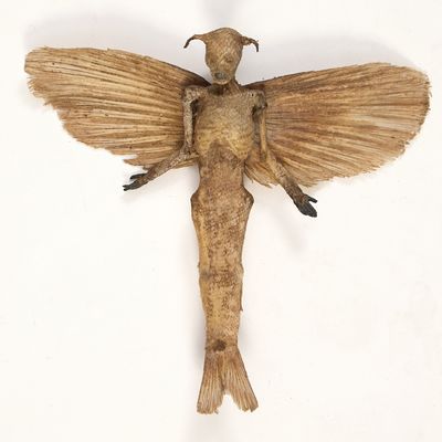 une sculpture en bois représentant un oiseau sur un fond blanc