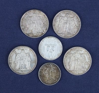 six pièces d'argent de tailles et de formes différentes sur fond bleu