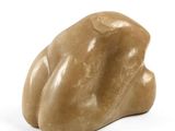 une sculpture représentant un rocher posé sur une surface blanche