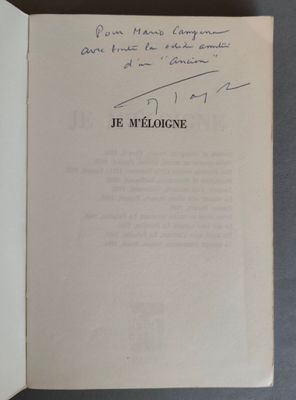un livre ouvert, dont une page est recouverte d'une écriture manuscrite, posé sur une table