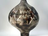 a black and white vase sitting on a white surface