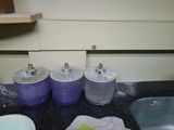 three blue containers sitting on a counter next to a sink
