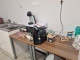 a kitchen with a sink and a counter with a coffee maker on it