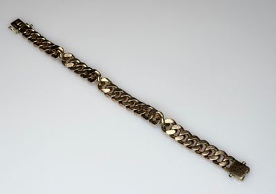 a close up of a metal bracelet on a white surface