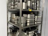 many pots and pans on the shelves in the kitchen