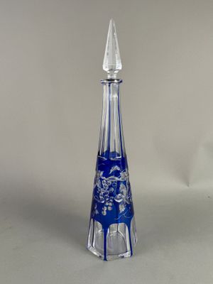 un vase en verre bleu et transparent orné d'un motif floral