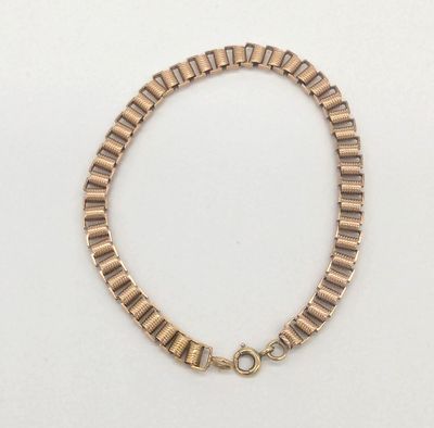 un bracelet en or avec un fermoir sur fond blanc