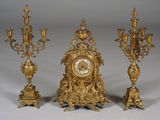 trois horloges dorées posées les unes à côté des autres sur une table