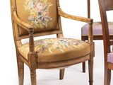 two wooden chairs with a floral upholstered back and arms