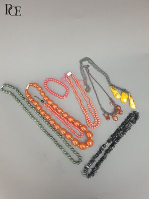 six perles de couleurs différentes sont disposées en ligne sur une surface blanche