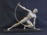statue en bronze représentant un homme avec un arc et une flèche, sur fond noir
