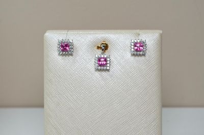 un gros plan sur une paire de boucles d'oreilles roses et blanches