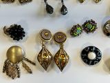 many different types of earrings on a white surface