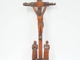 un vieux crucifix en bois représentant un homme sur la croix et deux enfants