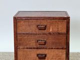 a brown chest of drawers sitting on top of a tiled floor