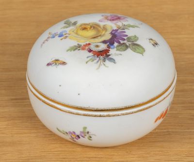 une petite boîte blanche décorée de fleurs, posée sur une table