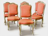 quatre chaises avec une assise rembourrée rouge et des finitions dorées