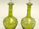 two green glass vases sitting on a white surface