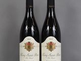 two bottles of wine sitting on top of a table next to each other