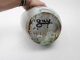 a hand that is holding a cup with graffiti on it