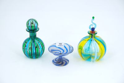 three different colored glass vases sitting next to each other on a white surface