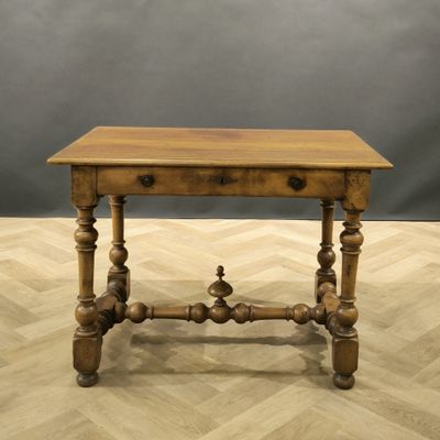 an old wooden table sitting on top of a hard wood floor
