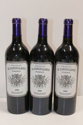 trois bouteilles de vin posées sur une table l'une à côté de l'autre